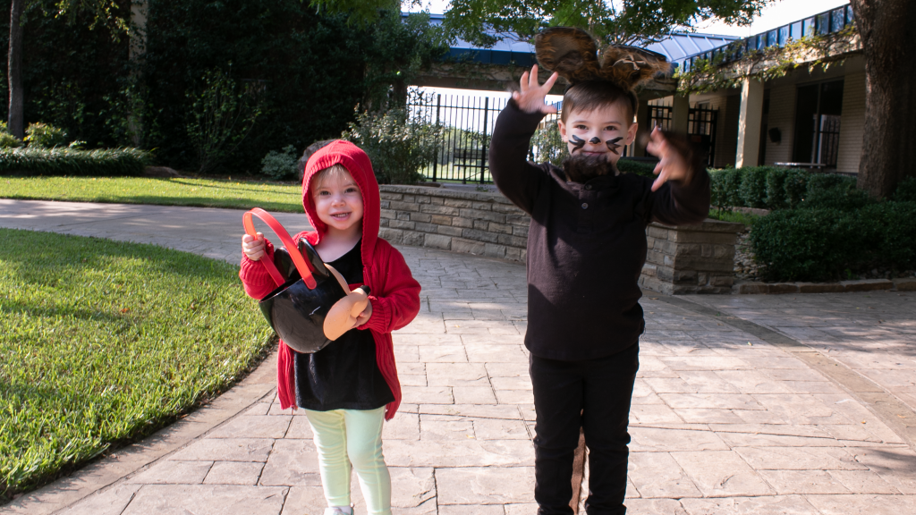 Two toddlers posing in their Halloween DIY Costumes as little red riding hood and the big bad wolf